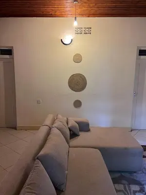 a couch against a wall with a clock on the wall at Nyani's hub in Moshi