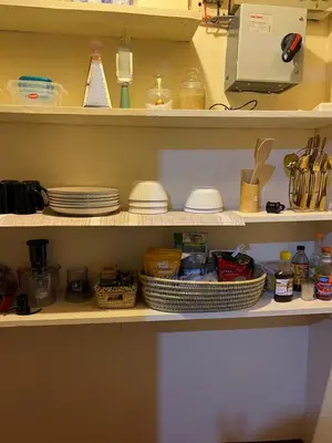a pantry with plates and dishes on shelves at Nyani's hub in Moshi