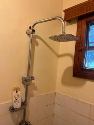 a shower in a bathroom with a light on the wall at Nyani's hub in Moshi