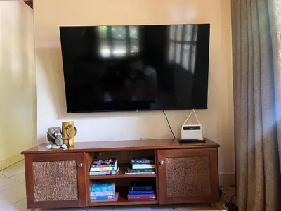 a flat screen tv on top of a entertainment center at Nyani's hub in Moshi
