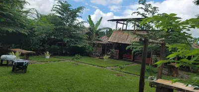 a garden with a house with a grass yard at Kidep Maasai Village in Moshi