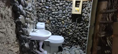a stone bathroom with a toilet and a sink at Kidep Maasai Village in Moshi