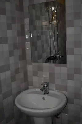 a bathroom with a white sink and a mirror at Volunteer House in Msaranga