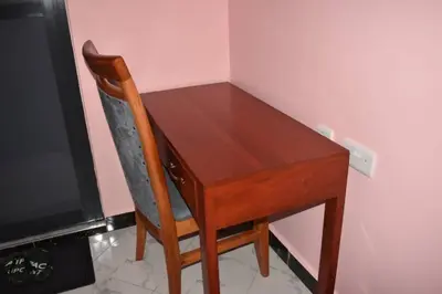 a wooden desk with a chair next to a tv at Volunteer House in Msaranga
