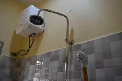 a shower in a bathroom with a shower head at Volunteer House in Msaranga