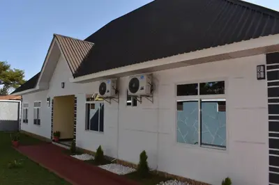 a white house with a black roof at Volunteer House in Msaranga