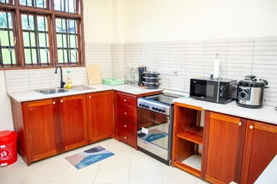 a kitchen with wooden cabinets and a microwave at Oasis Homestay in Arusha