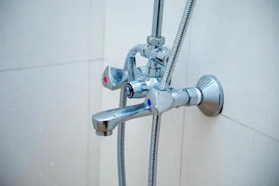 a metal shower faucet in a bathroom at Oasis Homestay in Arusha