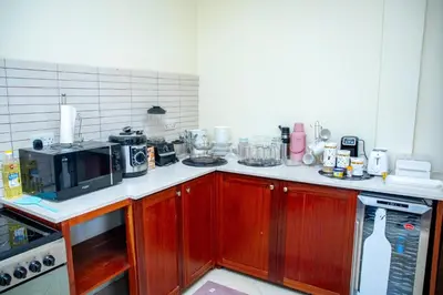 a kitchen with wooden cabinets and a counter top at Oasis Homestay in Arusha