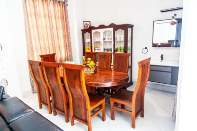 a dining room with a wooden table and chairs at Bienvenido a casa villa in Arusha