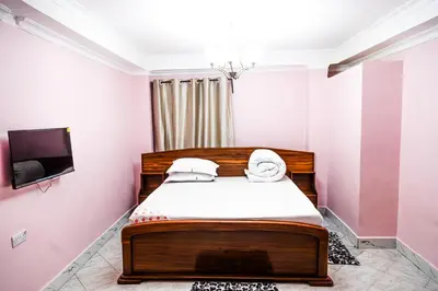 a bedroom with a bed and a flat screen tv at Bienvenido a casa villa in Arusha