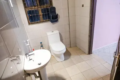 a bathroom with a toilet and a sink and a shower at Bienvenido a casa villa in Arusha