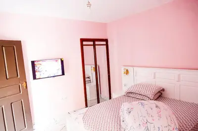 a bedroom with a bed and a mirror at Bienvenido a casa villa in Arusha