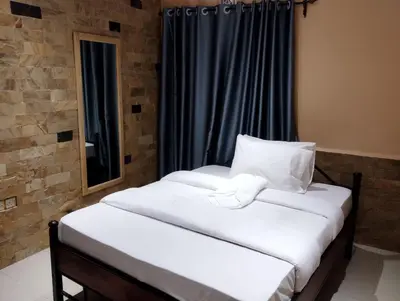 two twin beds in a room with a window at Moonshine hotel in Themi