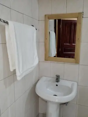 a white bathroom with a sink and a mirror at Moonshine hotel in Themi