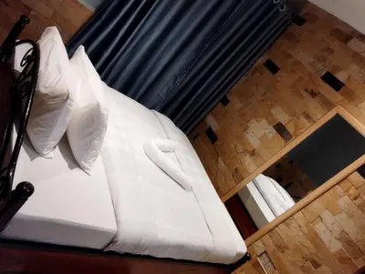 a bed with white sheets and pillows in a room at Moonshine hotel in Themi
