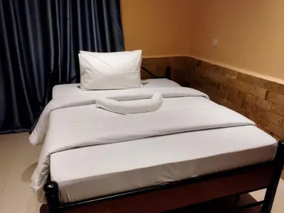 two beds with white sheets and pillows in a room at Moonshine hotel in Themi