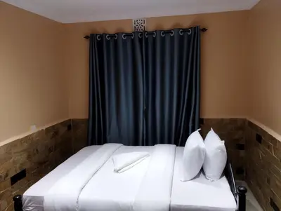 a bed with white pillows in front of a blue curtain at Moonshine hotel in Themi
