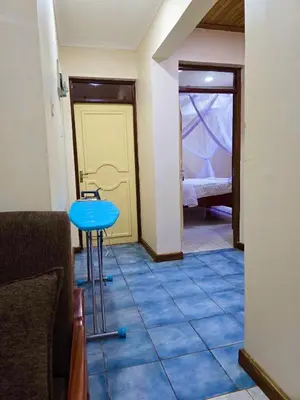 a room with a blue table and a bedroom at 2 bedrooms cozy house in Arusha in Arusha