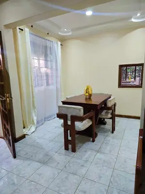 a dining room with a table and a bench at 2 bedrooms cozy house in Arusha in Arusha
