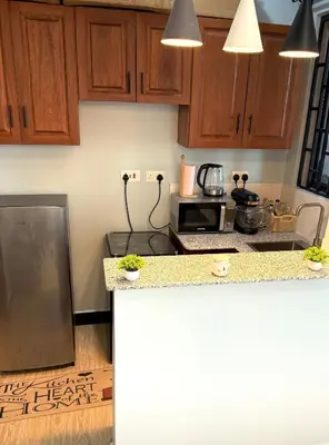 a kitchen with wooden cabinets and a counter top at Amaroz House in Nkunjila