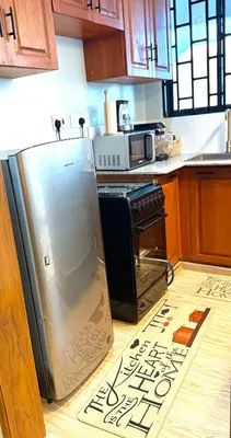 a kitchen with a refrigerator with a sign on the floor at Amaroz House in Nkunjila