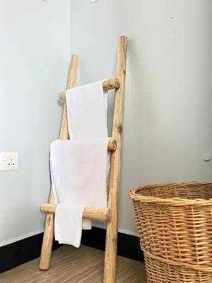 a wooden towel chair next to a basket at Amaroz House in Nkunjila
