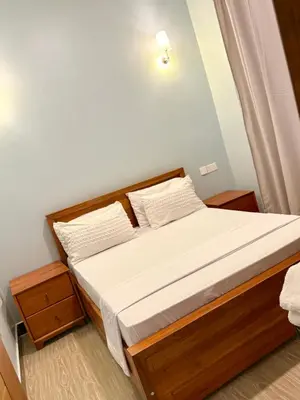 a small bedroom with a bed with white sheets at Amaroz House in Nkunjila