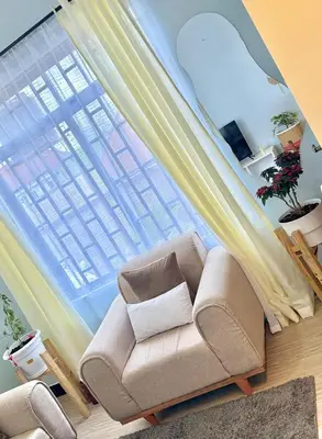 a living room with a couch and a large window at Amaroz House in Nkunjila