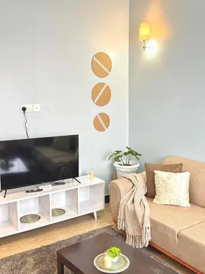 a living room with a couch and a tv at Amaroz House in Nkunjila