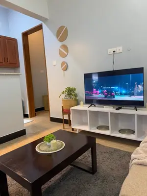 a living room with a large flat screen tv at Amaroz House in Nkunjila