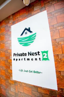 a sign on a brick wall with a private nest apartments sign at Private Nest Apartment 2 in Arusha