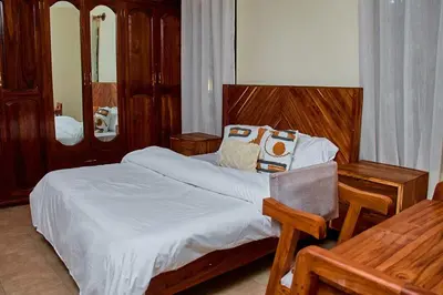 a bedroom with a large bed with a wooden headboard at Fusion of Style & Comfort in Arusha