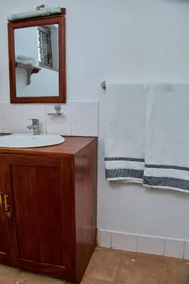 a bathroom with a sink and a mirror and a towel at Fusion of Style & Comfort in Arusha
