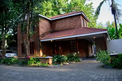 a red brick house with a courtyard in front of it at Fusion of Style & Comfort in Arusha