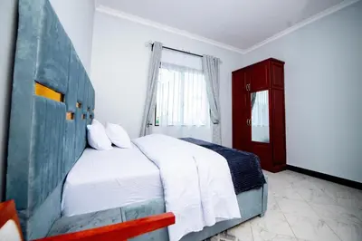 a bedroom with a white bed and a red cabinet at Private Nest Apartment 2 in Nkoanrua