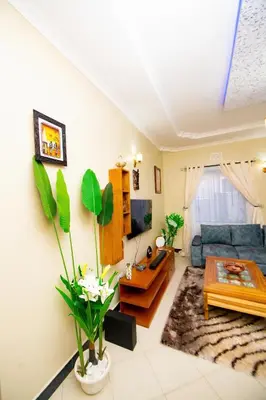 a living room with a blue couch and a table at Private Nest Apartment 2 in Nkoanrua