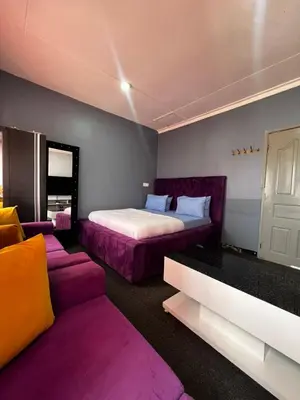 a bedroom with a bed and a couch at Hadraj Sokokuu Apartment1 in Arusha