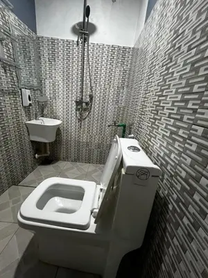 a bathroom with a toilet and a sink at Hadraj Sokokuu Apartment1 in Arusha