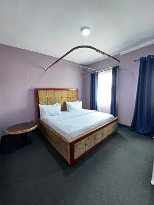 a bedroom with a large bed and a table at Hadraj Sokokuu Apartment3 in Arusha