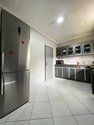 a kitchen with a stainless steel refrigerator and cabinets at Hadraj Sokokuu Apartment3 in Arusha