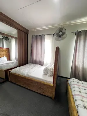 a bedroom with two beds and a window at Hadraj Sokokuu Apartment3 in Arusha