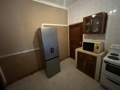 a small kitchen with a refrigerator and a microwave at Kitonga Escape in Msaranga