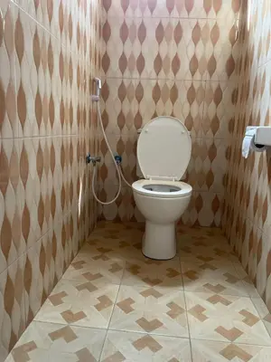 a bathroom with a toilet with a shower in it at R Kelly Tanzania in Arusha