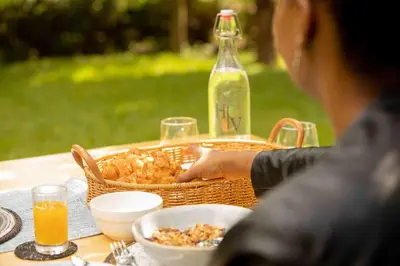 a person sitting at a table with a basket of food at The Hidden Valley Lodge in Arusha