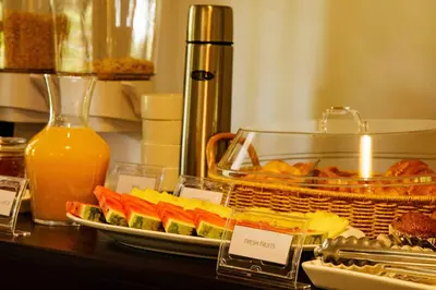 a buffet with a tray of food and a plate of sushi at The Hidden Valley Lodge in Arusha