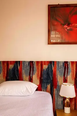 a bedroom with a bed and a picture on the wall at The Hidden Valley Lodge in Arusha