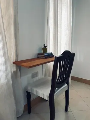 a chair sitting under a table with a wooden desk at Earth Villas in Arusha