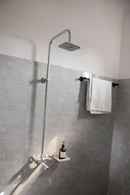 a shower stall with a bottle of soap on a shelf at Earth Villas in Arusha