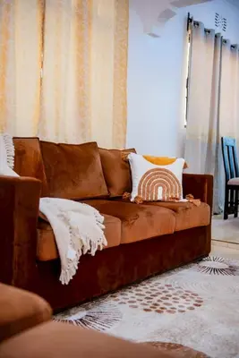 a brown couch sitting in a living room at Earth Villas in Arusha